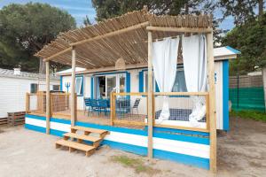 una pequeña casa azul y blanca con techo de madera en Maïana Resort en La Grande-Motte