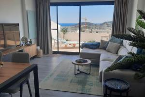 a living room with a couch and a table at Camporrosso Pool View Apartment in Finestrat