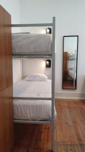 sypialnia z łóżkiem piętrowym i lustrem w obiekcie HI Coimbra - Pousada de Juventude w mieście Coimbra