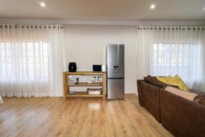 a living room with a couch and a refrigerator at Somethin Special in Mokopane +22 photos