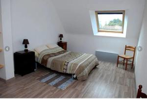 ein Schlafzimmer mit einem Bett, einem Fenster und einem Stuhl in der Unterkunft Maison de 4 chambres avec jardin amenage a Inzinzac Lochrist 