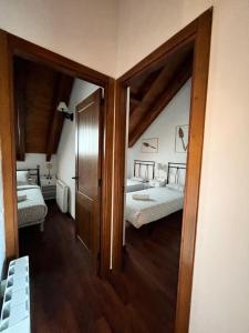 a room with two beds and a door to a bedroom at Luxury House Valencia D'Aneu in Valencia de Aneu