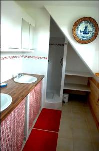 ein Badezimmer mit zwei Waschbecken und einer Dusche mit einem roten Teppich in der Unterkunft Maison de 4 chambres avec jardin amenage a Inzinzac Lochrist 
