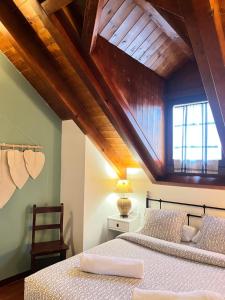 two beds in a room with a wooden ceiling at Luxury House Valencia D'Aneu in Valencia de Aneu
