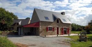 ein großes Steinhaus mit einer roten Tür in der Unterkunft Maison de 4 chambres avec jardin amenage a Inzinzac Lochrist 