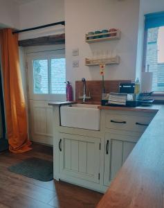 a kitchen with a white sink and a window at The Duddon Nest in Ulpha