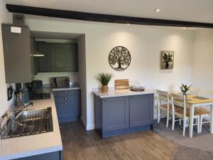 a kitchen and dining room with blue cabinets and a table at Hampstall Inn in Stourport