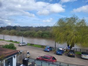 un grupo de coches estacionados en un estacionamiento junto a un río en Hampstall Inn, en Stourport