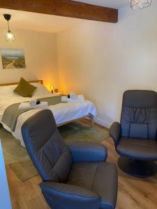 a bedroom with a bed and a couch and a chair at The Ivy Barn Holbeton in Plymouth