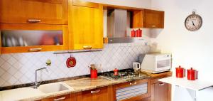 Una cocina con gabinetes de madera y un microondas blanco. en La Petite - Certaldo, en Certaldo 6 fotos más