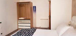 Un dormitorio pequeño con una cama y un refrigerador. en La Petite - Certaldo, en Certaldo