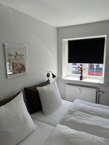 um quarto com 2 camas e uma televisão de ecrã plano em VISIONHOUSE Hotel em Frederikssund