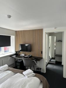 Habitación de hotel con 2 camas y escritorio en VISIONHOUSE Hotel, en Frederikssund