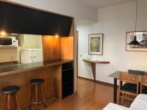una cucina con bancone e sgabelli in una stanza di Apart Hotel Guignard a Belo Horizonte