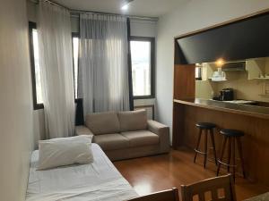 Habitación pequeña con sofá y cocina en Apart Hotel Guignard, en Belo Horizonte