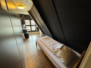 a small bed in a room with a wall at Hostel Utopia in Amsterdam