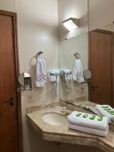 bagno con lavandino e specchio di Apart Hotel Guignard a Belo Horizonte