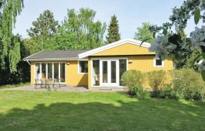 una casa amarilla con patio en Awesome Home In Tranekr With Wifi, en Tranekær