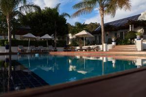 a swimming pool with chairs and umbrellas next to a building at theLAB Robertson in Robertson