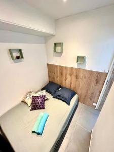 ein kleines Bett mit zwei Kissen darauf in einem Zimmer in der Unterkunft Appartement 3 pièces GREEN ART **** in Le Cannet + 10 Fotos