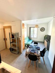 ein Wohnzimmer mit Tisch und Stühlen in der Unterkunft Appartement 3 pièces GREEN ART **** in Le Cannet