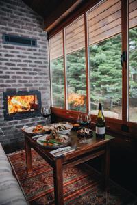 a table with food and wine glasses and a fireplace at Karinna Orman Koskleri in Uludag