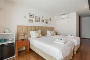 een slaapkamer met 2 bedden en een televisie bij Viravento - Guesthouse & Creative Space in Espinho