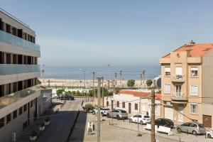 uitzicht op een stad met het strand en gebouwen bij Viravento - Guesthouse & Creative Space in Espinho