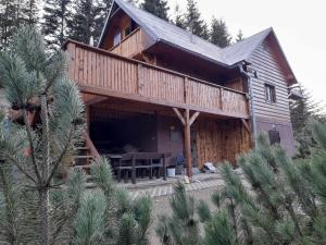 Cette grande maison en bois dispose d'une terrasse avec une table. dans l'établissement Chata Molik, à Lom nad Rimavicou