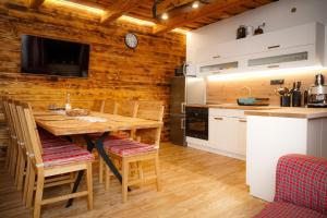 cocina y comedor con pared de madera en Chata Molik, en Lom nad Rimavicou