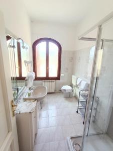 een badkamer met een wastafel, een douche en een toilet bij Appartamenti Villa Chiara in Imperia