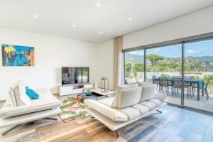 a living room with two white couches and a tv at Akwabay - Les Villas du Cap in Le Lavandou