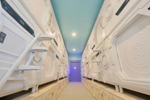 a hallway of an empty locker room with a blue door at Capsule Inn Bali in Legian