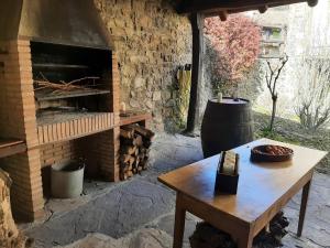 un horno de ladrillo con una mesa de madera y una chimenea en Olmares Apartamento Picos de Europa, en Pesaguero-La Parte