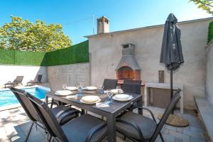 stół z krzesłami i parasol na patio w obiekcie Casa Romito w mieście Kaštelir
