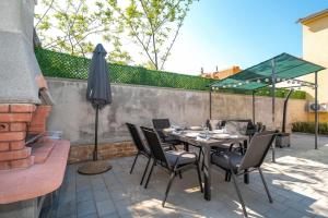 patio ze stołem, krzesłami i parasolem w obiekcie Casa Romito w mieście Kaštelir