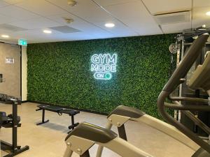 uma parede verde num ginásio com um letreiro de gymmode em Cityden Zuidas em Amstelveen