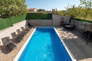 basen z krzesłami i stołem na patio w obiekcie Casa Romito w mieście Kaštelir
