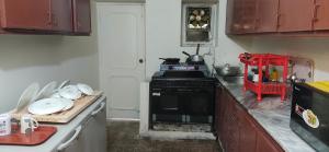 a kitchen with a black stove and a counter top at The Teal Cottage in Murree