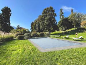a person standing next to a swimming pool in a park at Villa Artemisia by MyVillaCollection in Lenno