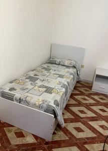 łóżko z kołdrą w sypialni w obiekcie Frichi house w mieście Lampedusa