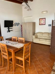 salon ze stołem, krzesłami i kanapą w obiekcie Frichi house w mieście Lampedusa