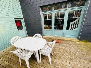 a white table and chairs sitting on a patio at Jacqueline in Étretat +7 photos