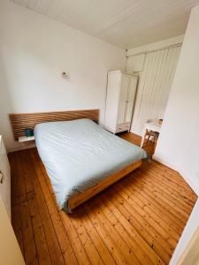 a small bedroom with a bed and a wooden floor at Jacqueline in Étretat