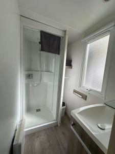 a white bathroom with a shower and a sink at Cottage 2 in Agarn +7 photos