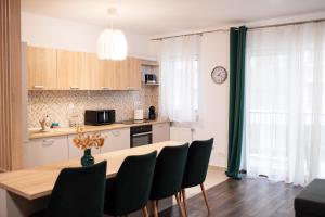 - une cuisine et une salle à manger avec une table et des chaises dans l'établissement Aria Sophia, à Cluj-Napoca