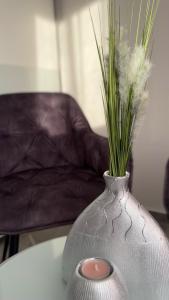 Eine Vase mit Gras auf einem Tisch. in der Unterkunft Luxus-Flat Wohnung-Hanau/Frankfurt in Hanau am Main