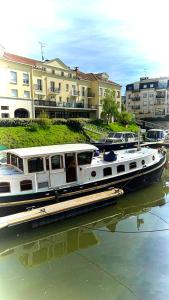 a boat is docked in the water next to buildings at LOFT SUR L'EAU AVEC BALNEO in Cergy