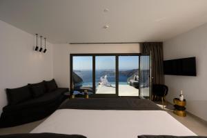 a bedroom with a bed and a view of the ocean at Arany Terra in Imerovigli