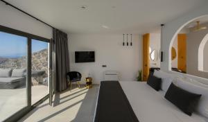 a bedroom with a bed and a large window at Arany Terra in Imerovigli